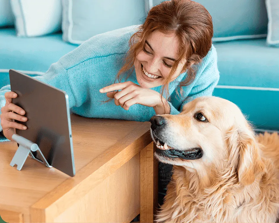Mulher com seu cachorro usando um tablet em casa